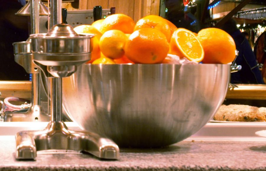 Frische Orangen und die Saftpresse am Tresen