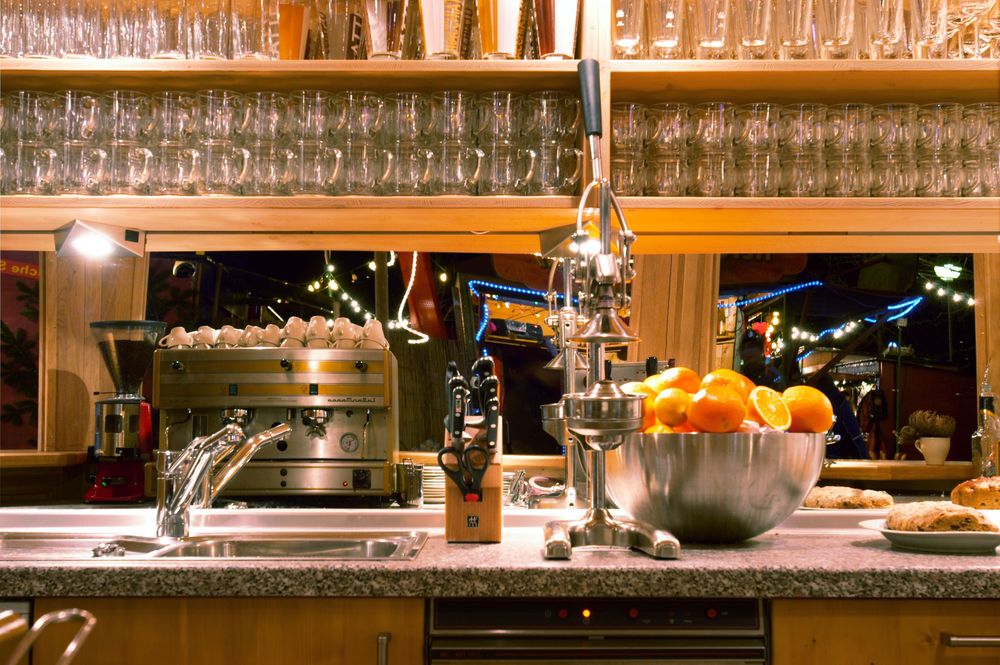 Blick über den Tresen der bio-bar: Gläser im Regal, frische Orangen und die Lichter des Christkindlmarkts